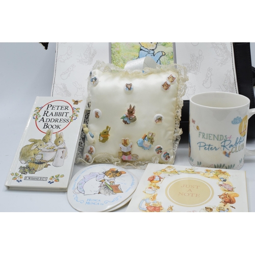 285 - A collection of Beatrix Potter collectables to include a Peter Rabbit handbag, cushion with pin badg... 