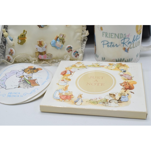 285 - A collection of Beatrix Potter collectables to include a Peter Rabbit handbag, cushion with pin badg... 