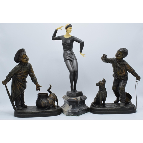 297 - A pair of bronzed spelter figures in the form of boys with animals and a Art-Deco style resin figure... 