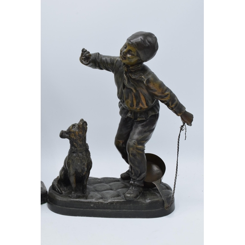 297 - A pair of bronzed spelter figures in the form of boys with animals and a Art-Deco style resin figure... 