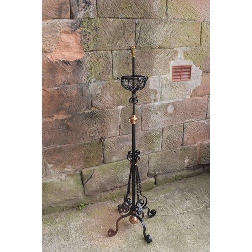 303 - A tall and adjustable metal and copper freestanding lamp with twisted iron work, 156cm tall.