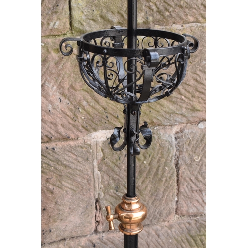 303 - A tall and adjustable metal and copper freestanding lamp with twisted iron work, 156cm tall.