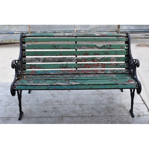 309 - A 20th century wooden and cast iron bench with wooden slats, 126cm wide.