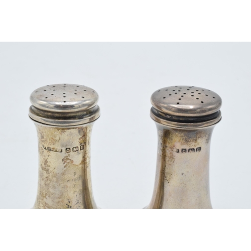 329 - A pair of silver shakers 48.7 grams. Birmingham 1911. 6cm tall.