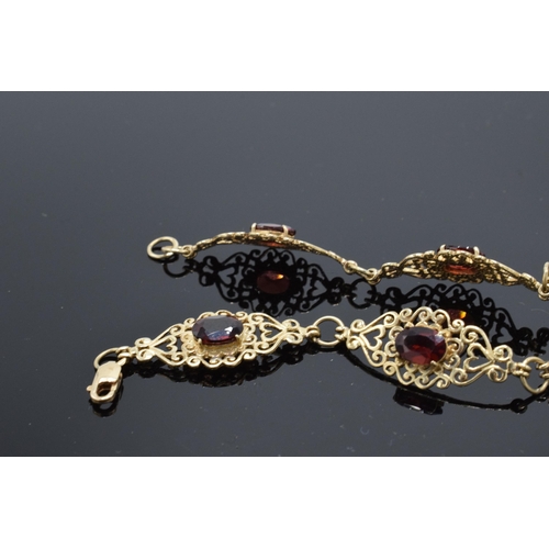 403 - 9ct gold ornate ladies bracelet set with garnets. 8.1 grams. 19.5cm long.