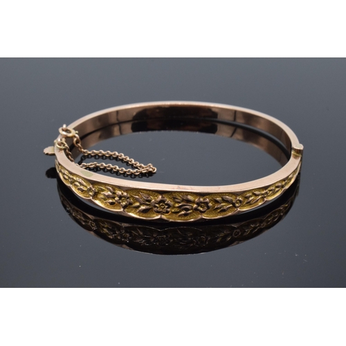 407 - 9ct gold ladies bangle with engraved decoration and safety chain. 6.9 grams.