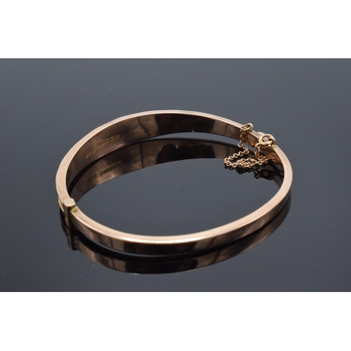 407 - 9ct gold ladies bangle with engraved decoration and safety chain. 6.9 grams.