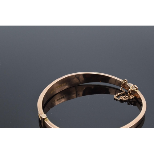 407 - 9ct gold ladies bangle with engraved decoration and safety chain. 6.9 grams.