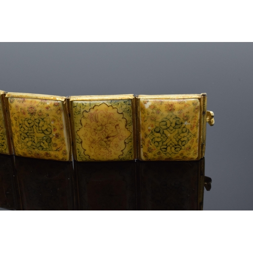 414 - Yellow metal and oriental panel bracelet. 19.5cm long.