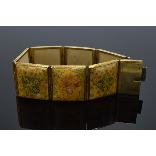 414 - Yellow metal and oriental panel bracelet. 19.5cm long.