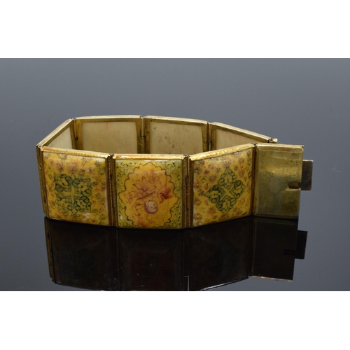 414 - Yellow metal and oriental panel bracelet. 19.5cm long.