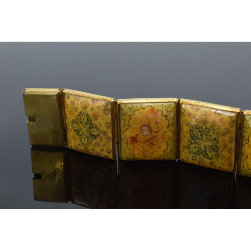 414 - Yellow metal and oriental panel bracelet. 19.5cm long.