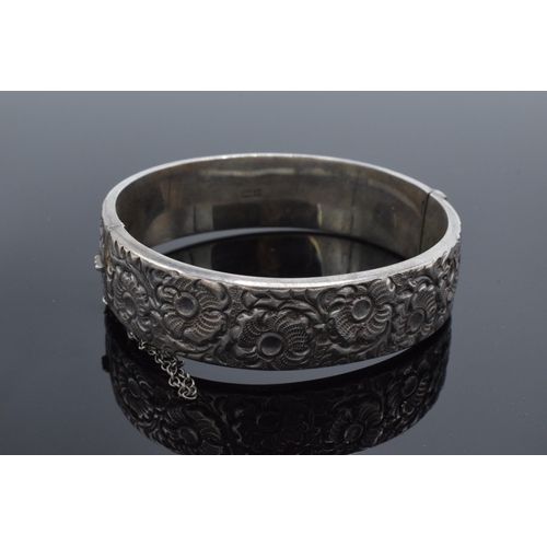 447 - A hallmarked silver ladies bangle with floral decoration, hallmarked for Liberty & Co. 25.4 grams.