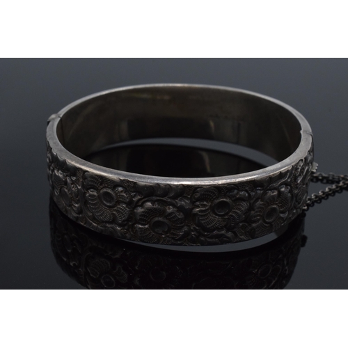 447 - A hallmarked silver ladies bangle with floral decoration, hallmarked for Liberty & Co. 25.4 grams.