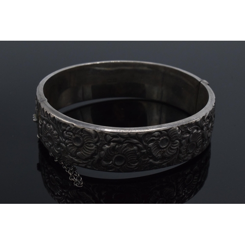 447 - A hallmarked silver ladies bangle with floral decoration, hallmarked for Liberty & Co. 25.4 grams.