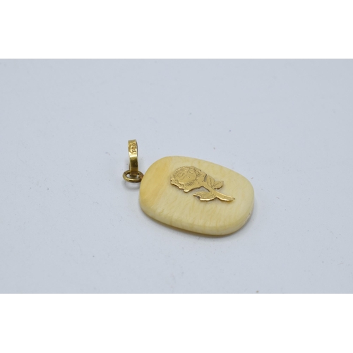 451 - A bone pendant with 18ct gold floral decoration and mount. 22mm tall.