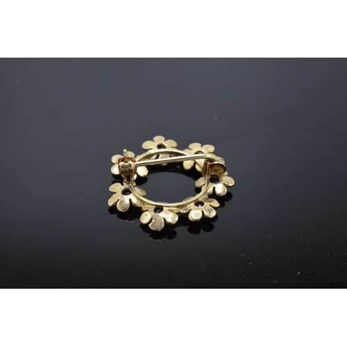 484 - 9ct gold circular brooch set with sapphires in a floral design, 2.3 grams.