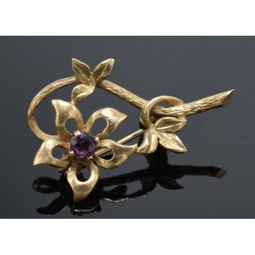 485 - 9ct gold brooch in the form of a blooming flower set with amethyst stone. 1.7 grams.