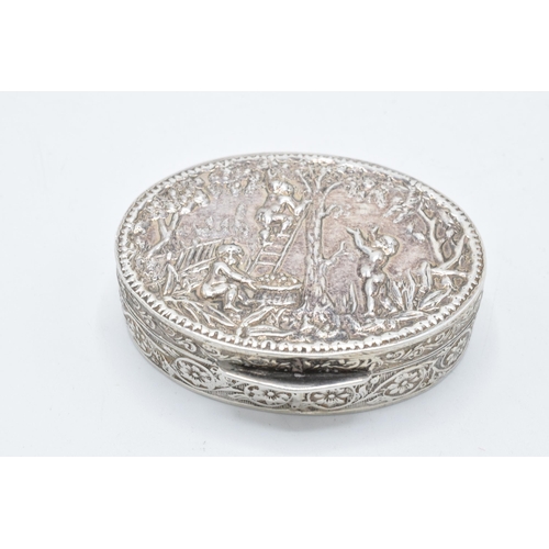 488 - An ornate sterling silver oval pill box with repousse cherub decoration with UK assay marks. 35.7 gr... 