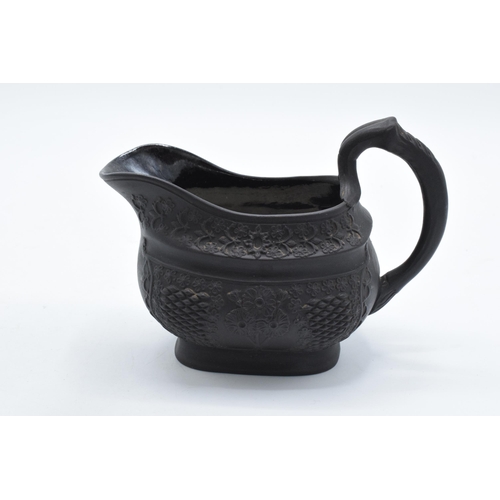 83 - A trio of early to mid 19th century black basalt cream jugs to include 2 examples with detailed flor... 