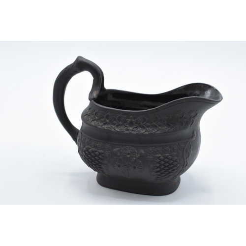 83 - A trio of early to mid 19th century black basalt cream jugs to include 2 examples with detailed flor... 