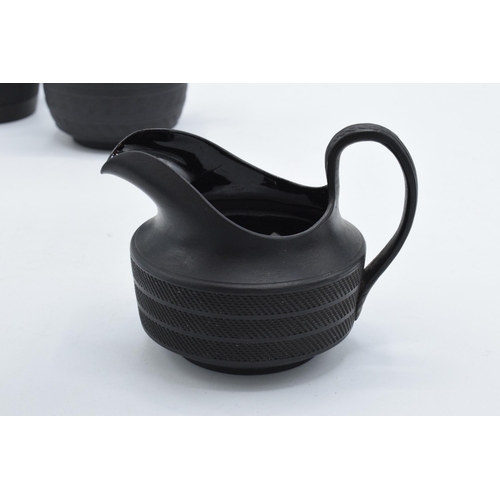 84 - A trio of 19th century black basalt cream jugs with engineered decoration to include one of tapering... 