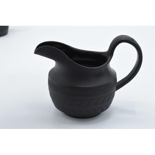 84 - A trio of 19th century black basalt cream jugs with engineered decoration to include one of tapering... 