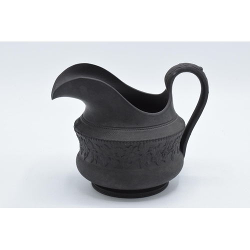 86 - A trio of 19th century black basalt cream jugs to of similar raised forms, one with lace ware design... 