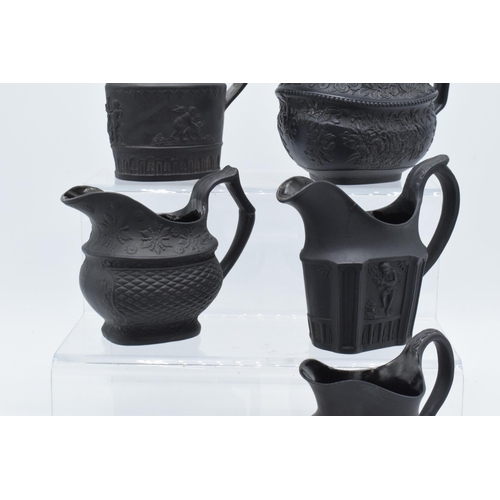 90 - A collection of mainly 19th century black basalt cream jugs to include a shallow Wedgwood example, j... 