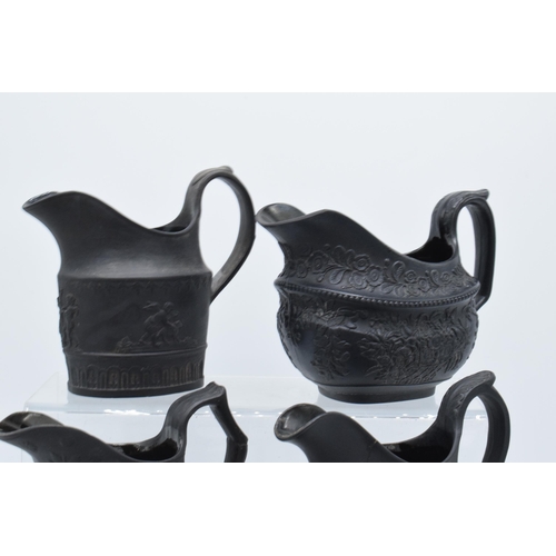 90 - A collection of mainly 19th century black basalt cream jugs to include a shallow Wedgwood example, j... 