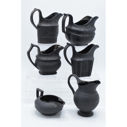 90 - A collection of mainly 19th century black basalt cream jugs to include a shallow Wedgwood example, j... 