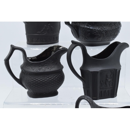 90 - A collection of mainly 19th century black basalt cream jugs to include a shallow Wedgwood example, j... 