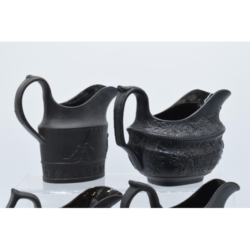 90 - A collection of mainly 19th century black basalt cream jugs to include a shallow Wedgwood example, j... 