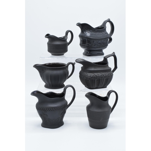 92 - A collection of mainly 19th century black basalt cream jugs to include a Wedgwood example in a modes... 