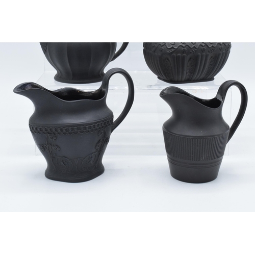 92 - A collection of mainly 19th century black basalt cream jugs to include a Wedgwood example in a modes... 