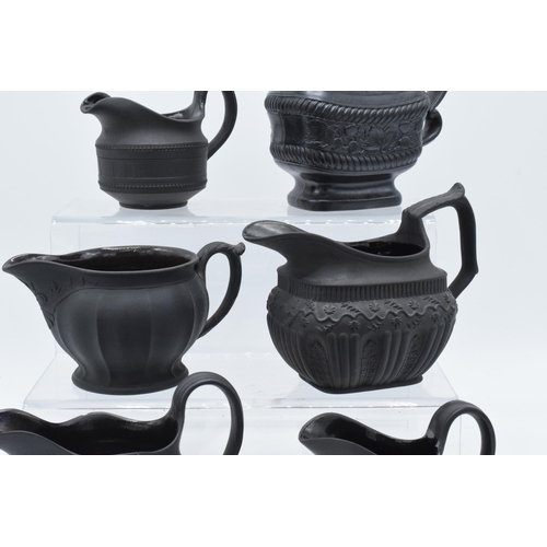 92 - A collection of mainly 19th century black basalt cream jugs to include a Wedgwood example in a modes... 