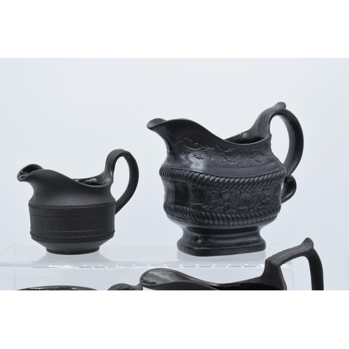 92 - A collection of mainly 19th century black basalt cream jugs to include a Wedgwood example in a modes... 