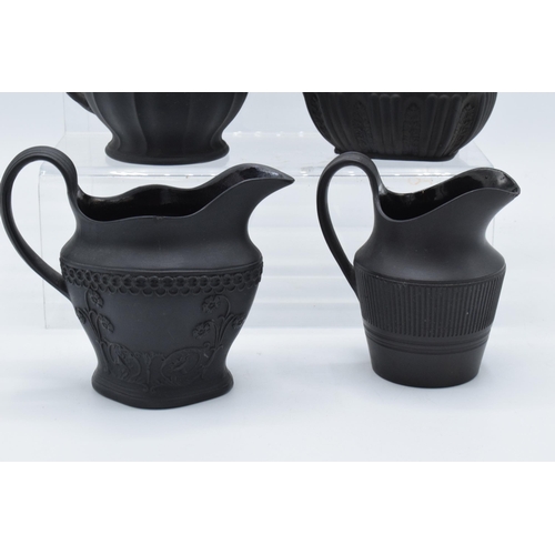 92 - A collection of mainly 19th century black basalt cream jugs to include a Wedgwood example in a modes... 