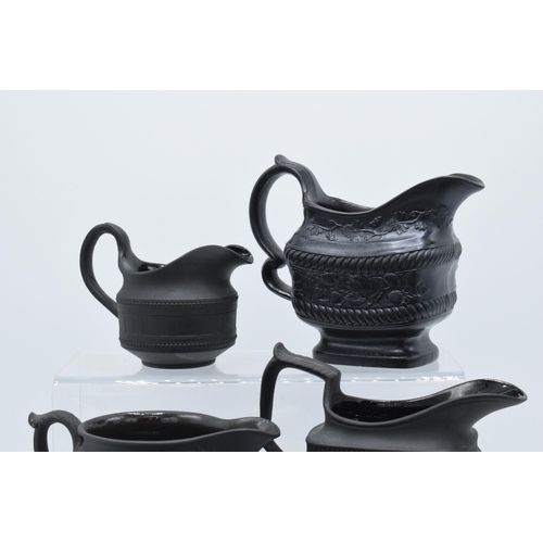 92 - A collection of mainly 19th century black basalt cream jugs to include a Wedgwood example in a modes... 