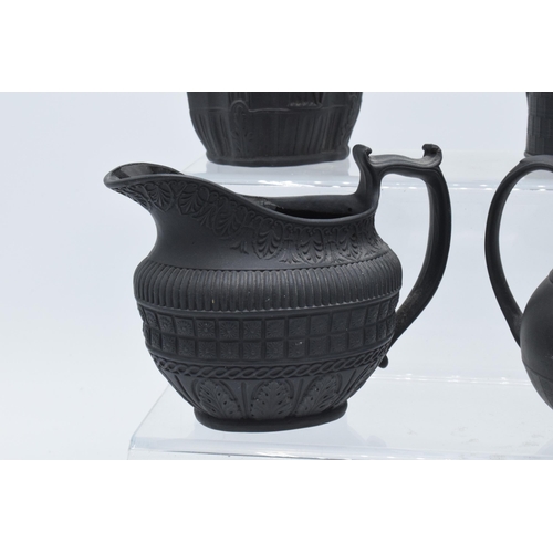 94 - A black basalt cream jug circa 1795 - 1800, attributed to Wilson, together with 3 others, the first ... 