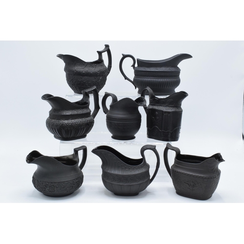 95 - A collection of early 19th century black basalt jugs to include a Wedgwood cream jug along with 7 ot... 