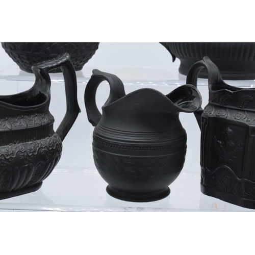 95 - A collection of early 19th century black basalt jugs to include a Wedgwood cream jug along with 7 ot... 