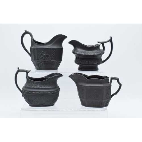 96 - A collection of black basalt milk jugs, circa 1800-1810, to include an oval example sprigged with 'H... 