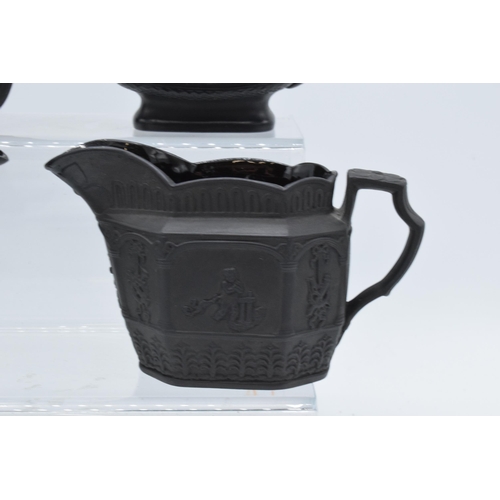 96 - A collection of black basalt milk jugs, circa 1800-1810, to include an oval example sprigged with 'H... 