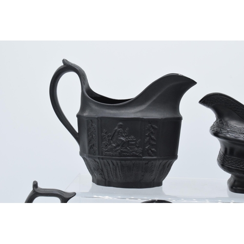 96 - A collection of black basalt milk jugs, circa 1800-1810, to include an oval example sprigged with 'H... 