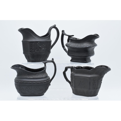 96 - A collection of black basalt milk jugs, circa 1800-1810, to include an oval example sprigged with 'H... 