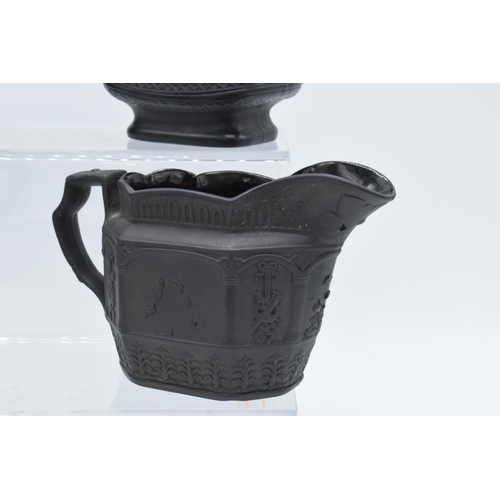 96 - A collection of black basalt milk jugs, circa 1800-1810, to include an oval example sprigged with 'H... 