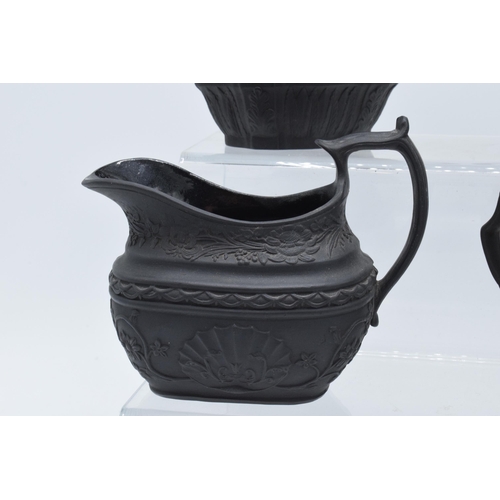 96 - A collection of black basalt milk jugs, circa 1800-1810, to include an oval example sprigged with 'H... 