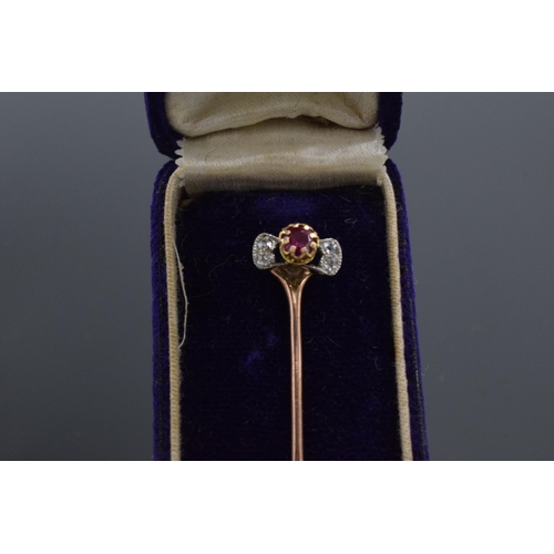 515 - 9ct gold diamond and ruby stick pin in case, 7.5cm long. 2.1 grams.