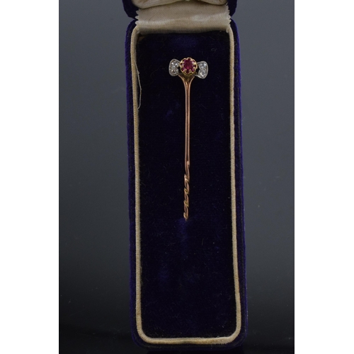 515 - 9ct gold diamond and ruby stick pin in case, 7.5cm long. 2.1 grams.